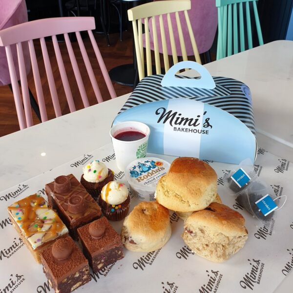 Cakes and scones next to a Mimi's Bakehouse box on a table