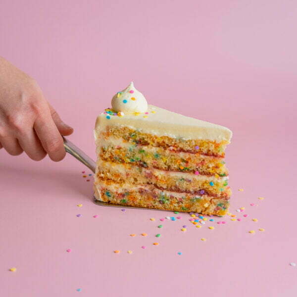 Person holding a slice of birthday cake