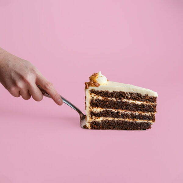 Person holding a slice of banana biscoff cake