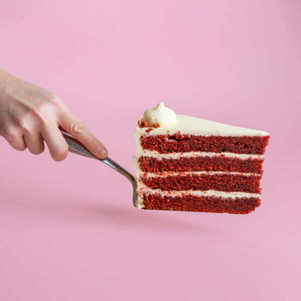 Person holding a slice of cake